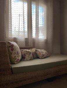um banco com almofadas sentadas em frente a uma janela em Sady's House em Yimnón