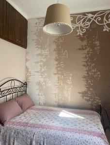 um quarto com uma cama, um candeeiro e uma parede em Sady's House em Yimnón