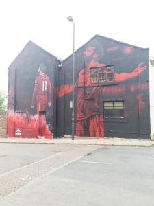 a building with a painting of two soccer players on it at L.F.C Townhouse in Anfield in Liverpool