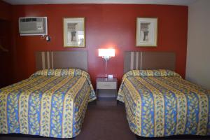 2 letti in una camera d'albergo con pareti rosse di South Hills Motel a Pittsburgh