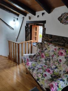 Una sala de estar con un sofá y una escalera. en Montanhas do Xisto - Casa do Portal, en Lousã