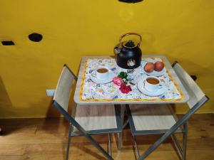 - une table avec 2 chaises et une bouilloire dans l'établissement Montanhas do Xisto - Casa do Portal, à Lousã