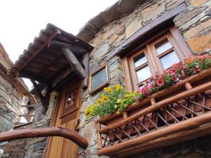 un edificio con un balcón con flores. en Montanhas do Xisto - Casa do Portal, en Lousã