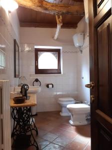 een badkamer met een wastafel, een toilet en een raam bij azienda agrituristica la torretta in Tocco da Casauria