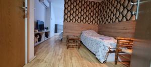 a bedroom with a bed with a wooden wall at Sobe Royal Apartman in Šabac