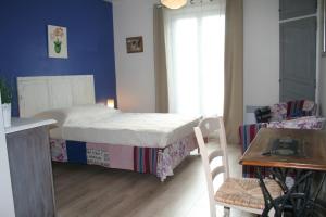 a small bedroom with a bed and a table at Chambres d'hôtes Le Puid de Gauthier in Saturargues