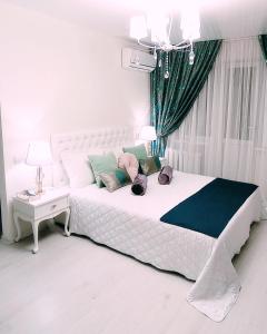 ein Schlafzimmer mit einem weißen Bett mit Kissen darauf in der Unterkunft Тиффани апартаменты in Dnipro