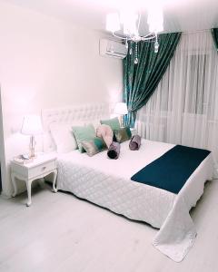 ein Schlafzimmer mit einem weißen Bett mit Kissen darauf in der Unterkunft Тіффані Апартаменти in Dnipro