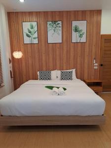 a bedroom with a large white bed with two towels on it at Sleep private khaoyai in Mu Si