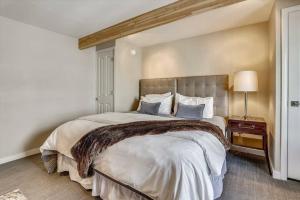 a bedroom with a large bed with a brown blanket at Downtown Aspen 2 Bedroom Condo in Aspen