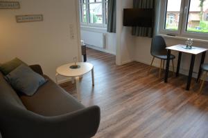 a living room with a couch and a table at Gasthof Zumdohme in Lastrup