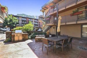 a patio with a table and chairs and a building at Downtown Aspen 2 Bedroom Condo in Aspen