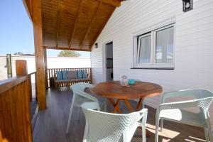 a patio with a wooden table and chairs on a deck at Casa Nordica cerca del mar in El Palmar