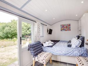 a bedroom with a bed and a sliding glass door at The Shepherd's Hut in Aberdyfi