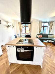 uma cozinha com fogão forno superior ao lado de uma sala de estar em Apartmán Elen em Nové Město nad Metují