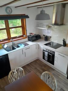 a kitchen with a sink and a stove top oven at 2 Harbour Row in Helmsdale