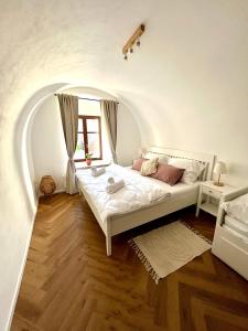 uma cama branca num quarto com uma arcada em Apartmán Elen em Nové Město nad Metují