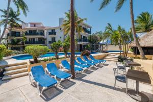 a row of blue chairs next to a swimming pool at Hotel Imperial Laguna Faranda Cancún in Cancún