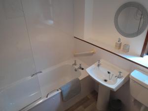 a bathroom with a tub and a sink and a mirror at 2 Harbour Row in Helmsdale