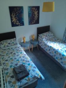 a room with two beds and two tables in it at 2 Harbour Row in Helmsdale