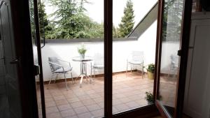 an open door to a patio with chairs and a table at Haus am Seerhein in Konstanz