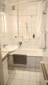 a white bathroom with a tub and a sink at Haus am Seerhein in Konstanz