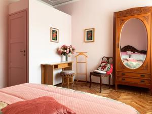 1 dormitorio con cama, tocador y espejo en Villa Delbia - Il Sogno, en Candelo