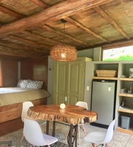 um quarto com uma mesa e cadeiras e uma cama em Acogedora cabaña en el bosque, Via La Calera em La Calera