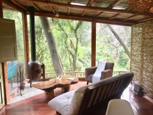 uma sala de estar com um sofá e uma mesa em Acogedora cabaña en el bosque, Via La Calera em La Calera