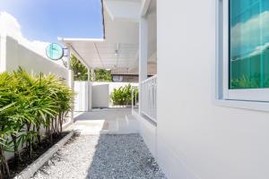 a hallway of a white building with plants at Ther house Banchang in Ban Chang