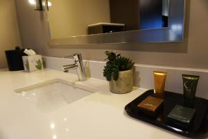 a bathroom counter with a sink and a mirror at Crescent Bay Inn in Laguna Beach