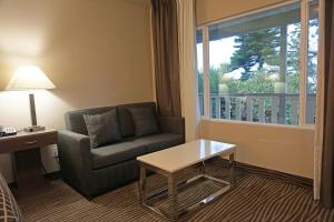 a living room with a couch and a table and a window at Crescent Bay Inn in Laguna Beach