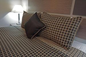 a bed with two pillows on top of it at Crescent Bay Inn in Laguna Beach