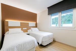 1 Schlafzimmer mit 2 Betten und einem Fenster in der Unterkunft Palacios 30, Playa Nanín in Sanxenxo