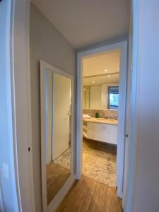 圣保罗JP Crauford Choice Suites的一间带镜子的浴室和一间带水槽的厨房