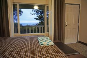 a bedroom with a bed and a large window at Crescent Bay Inn in Laguna Beach