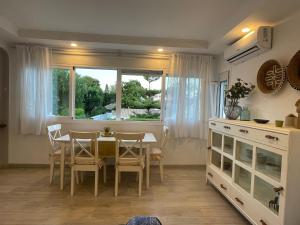 a dining room with a table and chairs and a window at Casa Violeta - Golf & tenis in Estepona