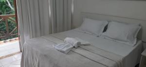 a white bed with white sheets and towels on it at Casa Moradas de Israel in Porto Seguro