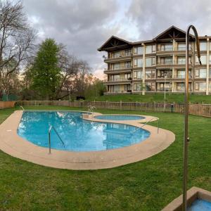 a large swimming pool in front of a building at Pucon villarrica in Pucón
