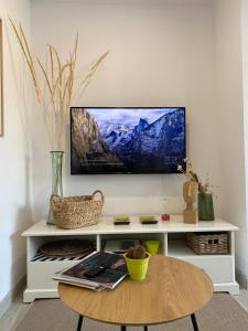 ein Wohnzimmer mit einem TV an der Wand in der Unterkunft Casa Violeta - Golf & tenis in Estepona