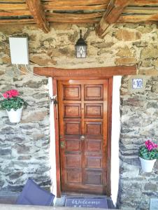 una puerta de madera en un edificio de piedra con dos plantas en La Casita del Árbol Blanco en Bubión