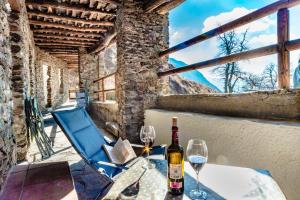 una mesa con una botella de vino y dos copas en La Casita del Árbol Blanco en Bubión