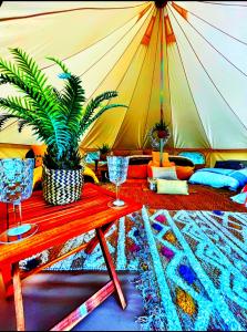 einen Tisch mit zwei Gläsern und ein Zelt in der Unterkunft CAYORETREAT LUXURY BELL TENT in Clodock