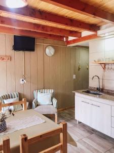 a kitchen with a table and a sink and a counter at Encanto Patagónico in El Bolsón
