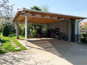 Una pérgola de madera con una bicicleta estacionada debajo. en Villa Delbia - L'Elfo, en Candelo