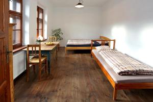Únětice的住宿－優拉斯古旅館，带两张床和一张桌子的房间以及一间用餐室