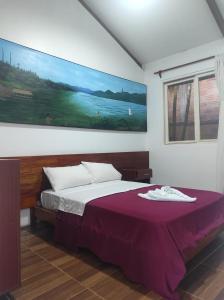 a bedroom with a bed with a painting on the wall at HOTEL BOUTIQUE PIWICHO in Sauce