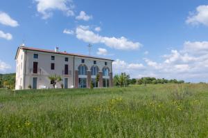 un bâtiment dans un champ d'herbe dans l'établissement Tenuta da Rino - Agriturismo Barco Menti, à Vicence