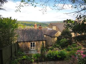 an old stone house with a garden in the foreground at Rose Cottage in Matlock