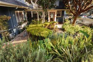 a garden in front of a house with plants at The Old St Angela Inn in Pacific Grove